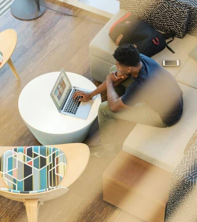 A focused man is diligently working on his laptop in the vibrant coworking space at Collab Cubicles, Whitefield. The modern workspace exudes an atmosphere of productivity and collaboration, providing professionals with an ideal environment to pursue their tasks and projects.